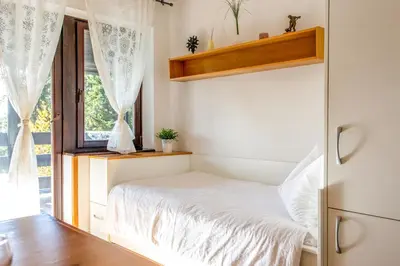 a small bedroom with a bed and a window at Apartma Planinski Raj in Zreče