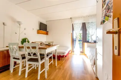 a kitchen and dining room with a table and chairs at Apartma Planinski Raj in Zreče