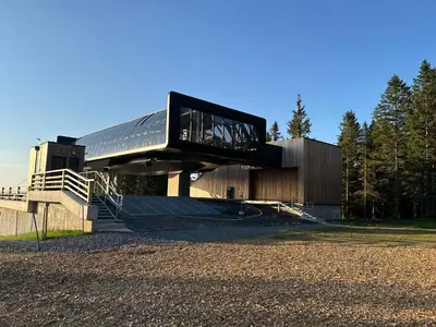a building with a black roof with a staircase at Apartma Planinski Raj in Zreče