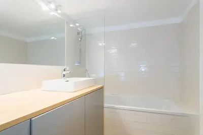a white bathroom with a sink and a shower at Chalet Ceri in Bohinj