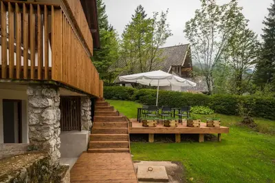 a patio with a table and an umbrella next to a house at Chalet Ceri in Bohinj
