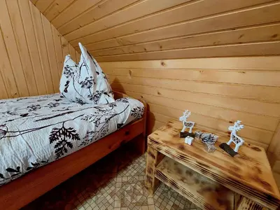 a room with a bed and a table in a log cabin at Koča Lipa pod Veliko planino in Luče