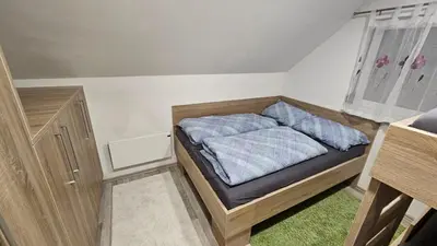 a small bedroom with a bed and a window at App DA-LI SPORT KOPE in Slovenj Gradec