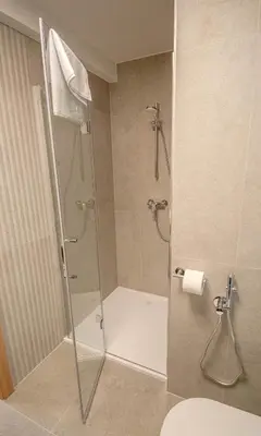 a shower with a glass door in a bathroom at Lake Bled Apartments in Bled