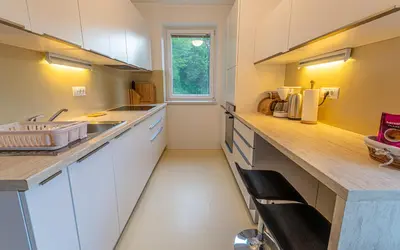 a kitchen with white cabinets and a sink and a window at Lake Bled Apartments in Bled