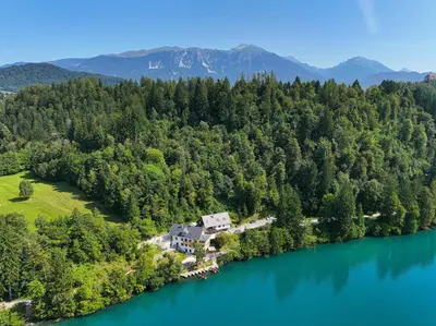 an aerial view of a house on the shore of a lake at Lake Bled Apartments in Bled