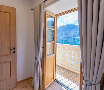 an open door to a balcony with a large window at Lake Bled Apartments in Bled