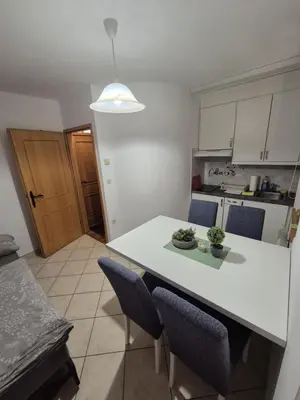 a kitchen with a white table and blue chairs at Marjetica 40 in Moravske Toplice