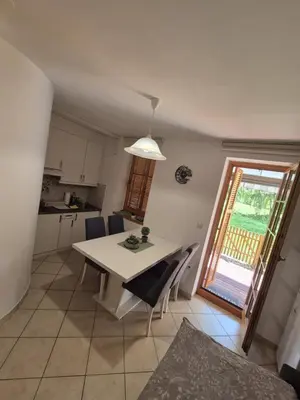a kitchen and dining room with a white table and chairs at Marjetica 40 in Moravske Toplice