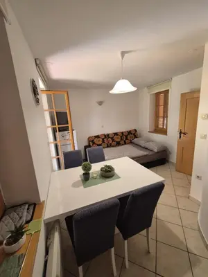 a kitchen and living room with a table and chairs at Marjetica 40 in Moravske Toplice