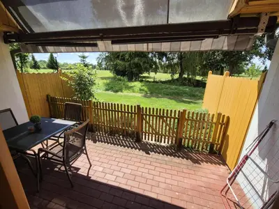 a patio with a table and chairs and a fence at Marjetica 40 in Moravske Toplice