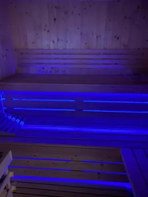 a row of wooden benches in a room with blue lights at Luxury House Ledine in Spodnja Idrija