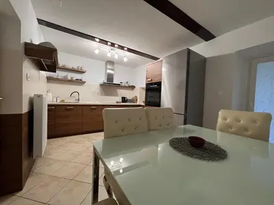 a kitchen and dining room with a table and chairs at Luxury House Ledine in Spodnja Idrija