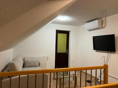 a living room with a couch and a tv on the wall at Luxury House Ledine in Spodnja Idrija