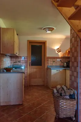 a kitchen with a counter and a basket of logs at Holiday house Pokrovec - Bohinj in Bohinj