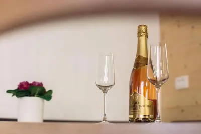 a bottle of champagne and two glasses on a table at Holiday house Pokrovec - Bohinj in Bohinj