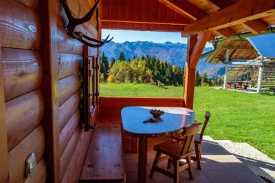 a table and chairs on the porch of a cabin at Holiday house Pokrovec - Bohinj in Bohinj