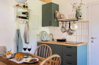 a kitchen with a table with wine glasses at Posestvo Brida - Glamping in Ilirska Bistrica