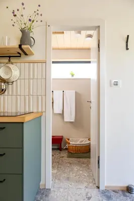a kitchen with a door leading into a bathroom at Posestvo Brida - Glamping in Ilirska Bistrica