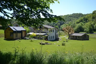 a large house in a field with a grass yard at Posestvo Brida - Glamping in Ilirska Bistrica