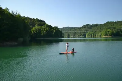 a man and a child on a boat on a lake at Posestvo Brida - Glamping in Ilirska Bistrica