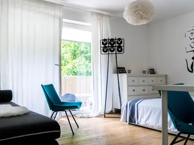 a bedroom with blue chairs and a bed and a window at A modern flat in Kranjska Gora