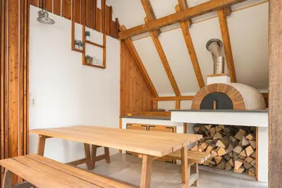 a dining room with a table and a wood oven at A modern flat in Kranjska Gora