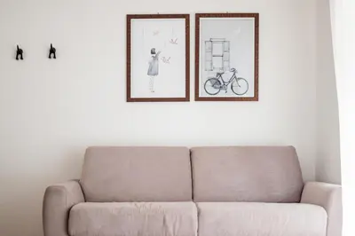 a couch in a living room with two pictures on the wall at A modern flat in Kranjska Gora