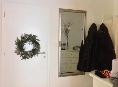 a bathroom with a mirror and a wreath on the door at A modern flat in Kranjska Gora