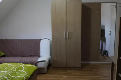 a bedroom with a bed and a cabinet with a door at Hiša nasprot Sonca in Črnomelj