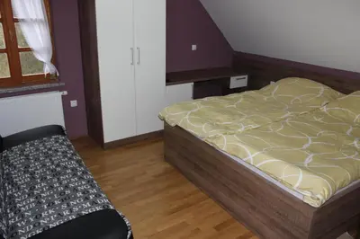 a bedroom with a bed and a bench in it at Hiša nasprot Sonca in Črnomelj