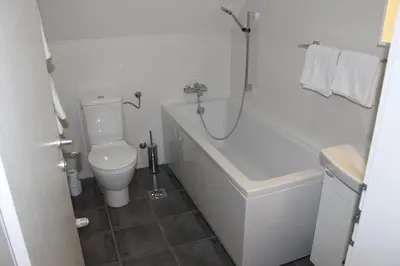 a bathroom with a toilet and a tub and a sink at Hiša nasprot Sonca in Črnomelj
