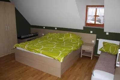 a bedroom with a bed with a yellow comforter at Hiša nasprot Sonca in Črnomelj