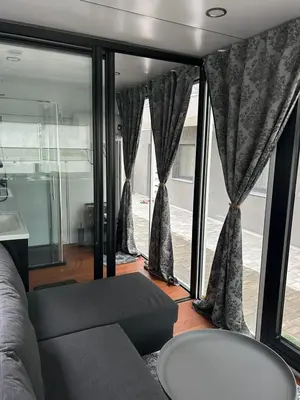 a living room with a couch and some windows at mobile house Rest Area in Ljubljana