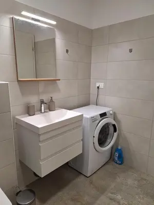 a bathroom with a washing machine and a sink at Agregat in Ljubljana