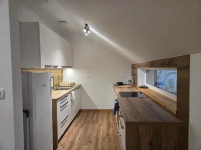 a kitchen with white appliances and a wooden counter top at Agregat in Ljubljana