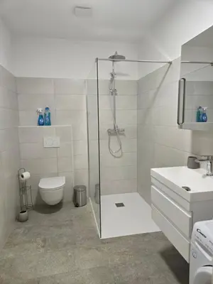 a bathroom with a shower and a toilet and a sink at Agregat in Ljubljana