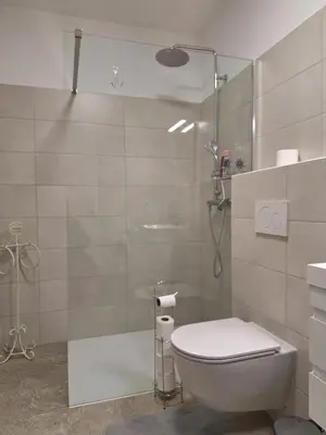 a bathroom with a shower and a toilet and a sink at Agregat in Ljubljana