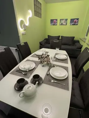 a dining room table with plates and glasses on it at Blue Sky Apartment in Bled