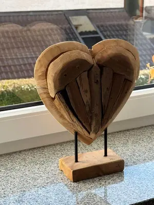 a wooden heart on a stand in front of a window at Blue Sky Apartment in Bled