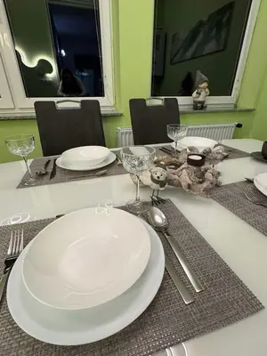 a table with white plates and silverware on it at Blue Sky Apartment in Bled
