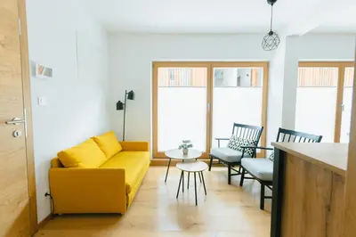 a living room with a yellow couch and chairs at Nordic House Apartment A1 in Kranjska Gora