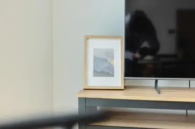 a picture frame sitting on a table next to a tv at Nordic House Apartment A1 in Kranjska Gora
