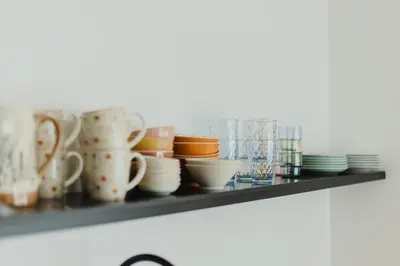 a shelf with cups and plates on it at Nordic House Apartment A1 in Kranjska Gora