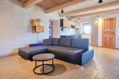 a living room with a blue couch and a table at Hisa na Zlatem polju in Lukovica pri Domžalah