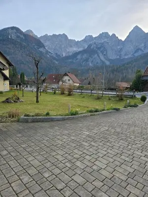 a brick road with mountains in the background at Apartmaji PRI JUNESKO in Kranjska Gora