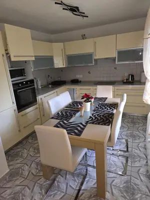 a kitchen with a table with white chairs around it at Apartmaji PRI JUNESKO in Kranjska Gora