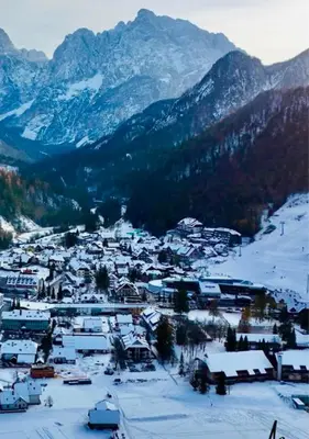 a small town in the snow with mountains at Apartment Misty Forest in Kranjska Gora