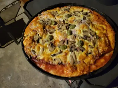 a pizza in a pan sitting on a stove at Kmečka Vila in Višnja Gora
