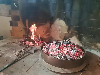 a large pot of candy in front of a fire at Kmečka Vila in Višnja Gora